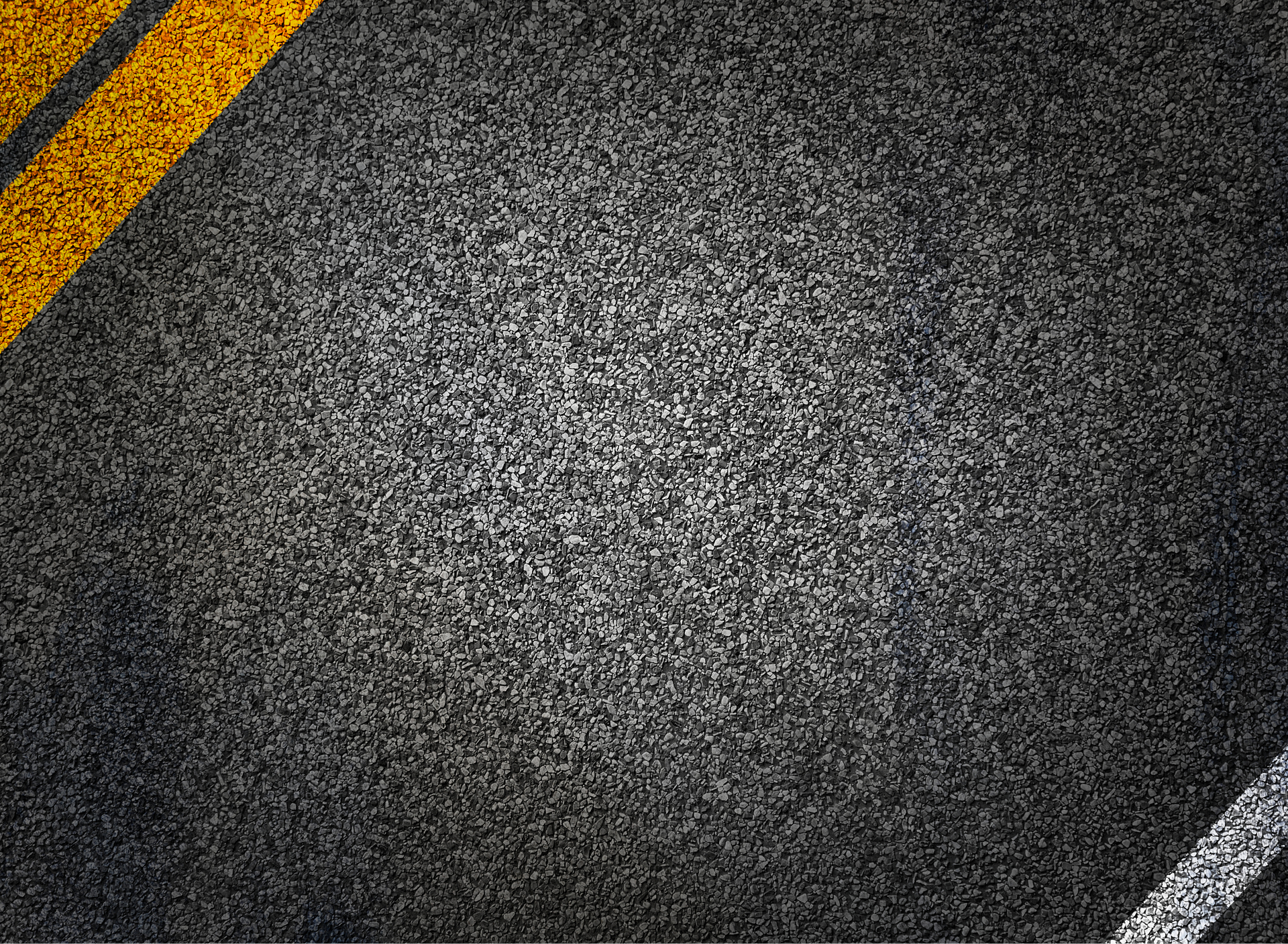 Textura de asfalto com faixas amarelas no canto superior esquerdo e uma faixa branca no canto inferior direito.